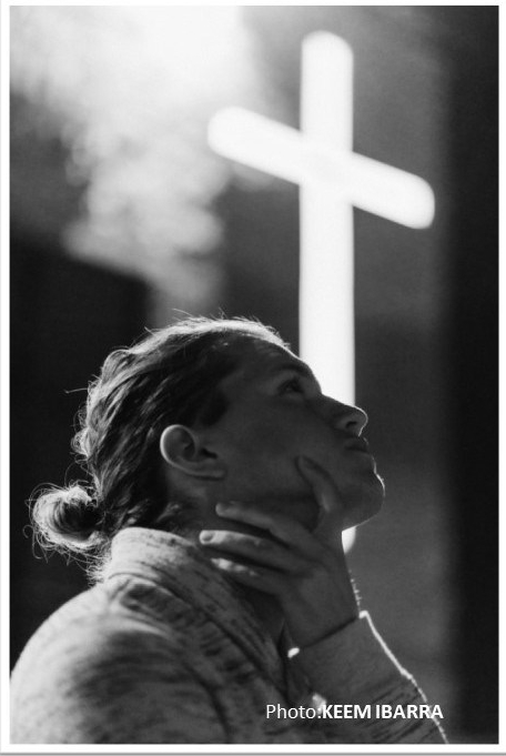 Praying girl at cross